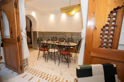 a dining room with a table and chairs and wine bottles at Riad Näjma Medina, privatisation, 8 personnes 2 Bassins in Marrakech