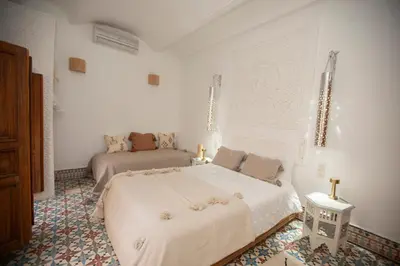 a white bedroom with a bed and a couch at Riad Näjma Medina, privatisation, 8 personnes 2 Bassins in Marrakech