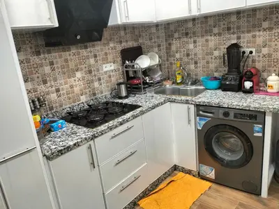 a kitchen with a stove top oven next to a washing machine at Betterappart in Marrakech