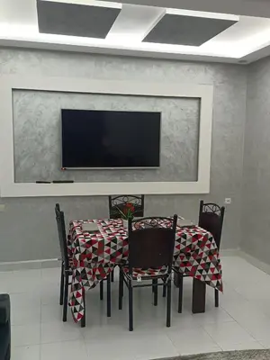 a dining room with a table with chairs and a tv at Betterappart in Marrakech