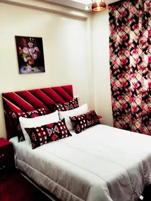 a bedroom with a bed with red and black pillows at Betterappart in Marrakech