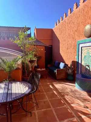 a patio with a table and chairs on a balcony at Riad FARASHA in Marrakech