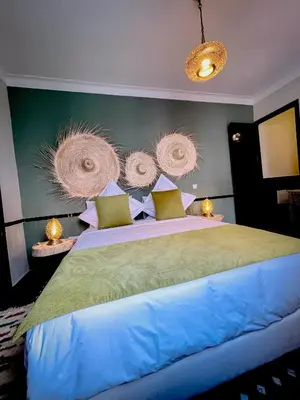 a bedroom with a large bed with somewheels on the wall at Riad FARASHA in Marrakech