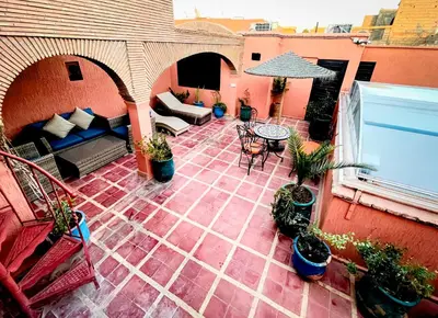 an outdoor patio with a couch and a table at Riad FARASHA in Marrakech