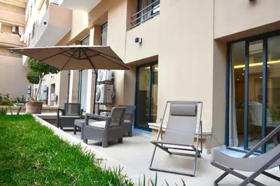 a patio with chairs and an umbrella next to a building at Duplex Safiya Suites and Services in Marrakech