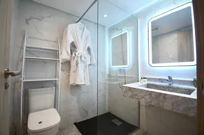 a bathroom with a toilet and a sink and a mirror at Duplex Safiya Suites and Services in Marrakech