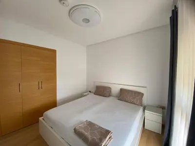 a small bedroom with a white bed and wooden cabinets at Breathtaking views of golf in Marrakech