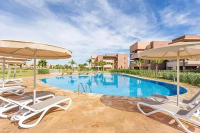 a swimming pool with lounge chairs and umbrellas at Breathtaking views of golf in Marrakech