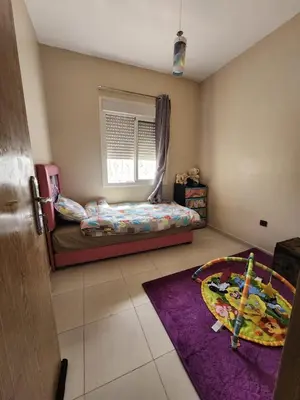 a bedroom with a bed and a window and a rug at Comfortable apartment near the Airport in Marrakech