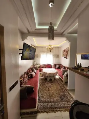 a living room with a red couch and a table at Comfortable apartment near the Airport in Marrakech