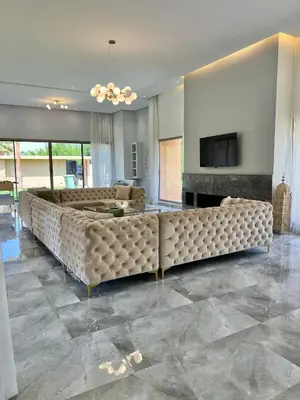 a living room with a large couch and a television at Les Villas de Marrakech in Marrakech