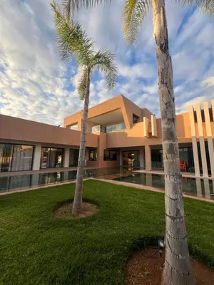 two palm trees in front of a building at Les Villas de Marrakech in Marrakech