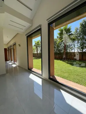 a room with large windows and a view of a yard at Les Villas de Marrakech in Marrakech