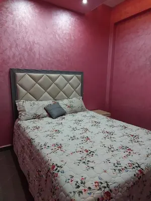 a bedroom with a bed with a floral bedspread at Garden View in Marrakech