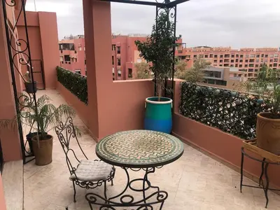 a balcony with a table and chairs on a balcony at Wonderful apartment pool residence Babylon in Marrakech