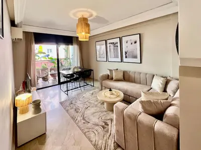 a living room with a couch and a table at Appartement idyllique au centre ville in Marrakech