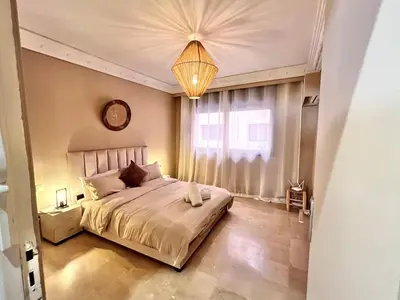 a bedroom with a large bed and a clock on the wall at Appartement idyllique au centre ville in Marrakech