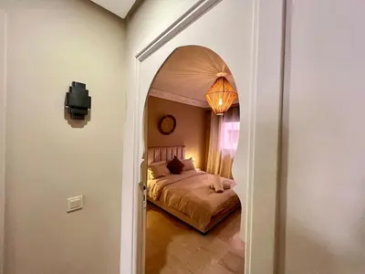 a bedroom with a bed and an arched doorway at Appartement idyllique au centre ville in Marrakech