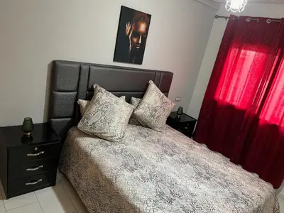 a bedroom with a large bed with red curtains at Hoteghani in Marrakech