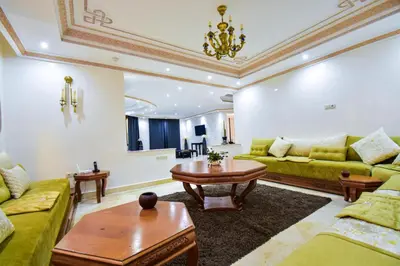 a living room with green couches and a table at holiday villa in marrakech in Marrakech