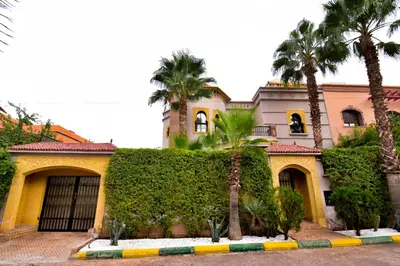 a building with palm trees in front of it at holiday villa in marrakech in Marrakech