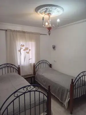 a bedroom with two beds and a chandelier at Appartement in Marrakech