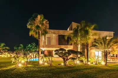 a large house with palm trees in front of it at Villa Lalla Fattoma in Marrakech