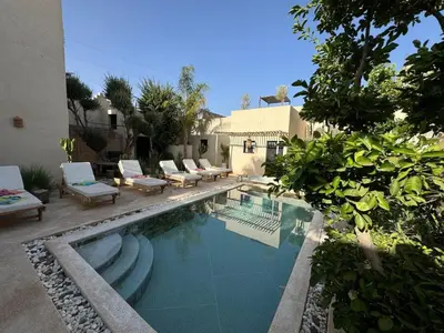 a swimming pool with lounge chairs and a house at Run Villa Marine, Elegant Private Villa in Marrakech with Heated Pool Option in Marrakech