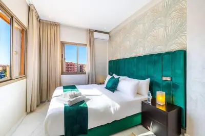 a bedroom with a large bed with a green headboard at Cocon Chaleureux au Cœur de la Ville in Marrakech