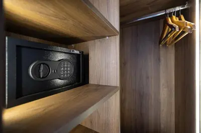 a black microwave in a wooden shelf in a kitchen at Cocon Chaleureux au Cœur de la Ville in Marrakech
