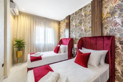 two beds in a room with red and white at Cocon Chaleureux au Cœur de la Ville in Marrakech