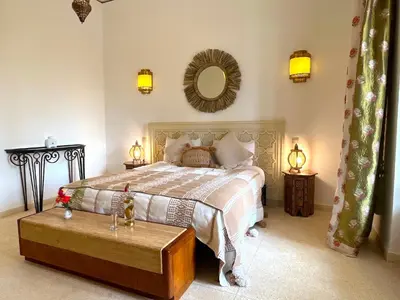 a bedroom with a bed and a table and a mirror at Palais Debora in Marrakech