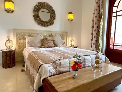 a bedroom with a bed with a table and a mirror at Palais Debora in Marrakech