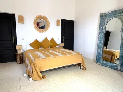 a bedroom with a bed and a large mirror at Palais Debora in Marrakech