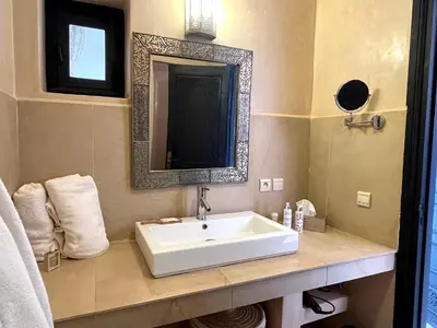 a bathroom with a white sink and a mirror at Palais Debora in Marrakech