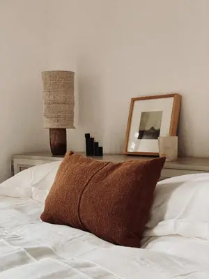 a pillow on a bed with a picture and a lamp at Riad Berbère Marrakech in Marrakech