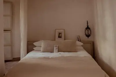 a white bed with pillows in a bedroom at Riad Berbère Marrakech in Marrakech