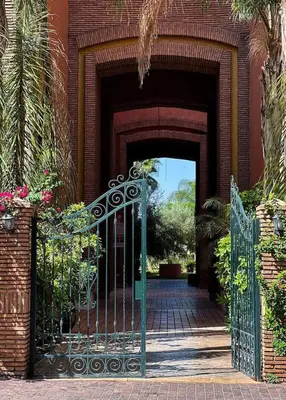 an entrance to a brick building with a green gate at Hivernage appartement premium in Marrakech