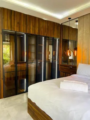 a bedroom with a large white bed and wooden walls at Hivernage appartement premium in Marrakech