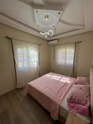 a bedroom with a bed with pink sheets and windows at very nice house in Marrakech