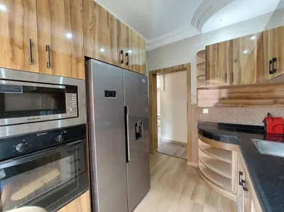 a kitchen with stainless steel appliances and wooden cabinets at very nice house in Marrakech