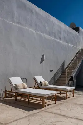 two lounge chairs sitting next to a concrete wall at Dar Babette in Marrakech