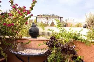 a garden with a table and some plants and flowers at superbe riad en exclusivité B&B in Marrakech