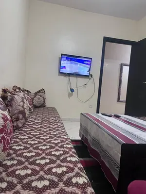 a room with a bed and a flat screen tv on the wall at Yassmirouaq in Marrakech
