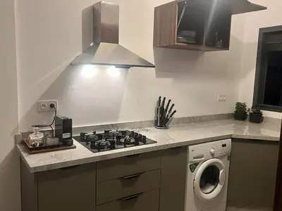 a kitchen with a stove top oven next to a washing machine at Appartement tout neuf à Gueliz Marrakech Plaza Zara in Marrakech