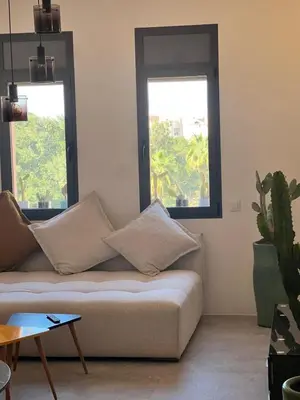 a living room with a couch and two windows at Appartement tout neuf à Gueliz Marrakech Plaza Zara in Marrakech