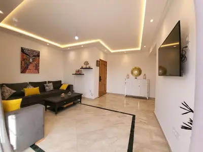 a living room with a couch and a table at Wonderful apartment pool residence Babylon 2- chambre in Marrakech
