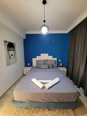 a blue bedroom with a large bed with two towels at Wonderful apartment pool residence Babylon 2- chambre in Marrakech