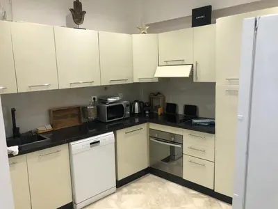 a kitchen with white cabinets and a microwave at Wonderful apartment pool residence Babylon 2- chambre in Marrakech