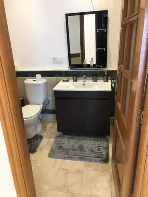 a bathroom with a toilet and a sink and a mirror at Wonderful apartment pool residence Babylon 2- chambre in Marrakech